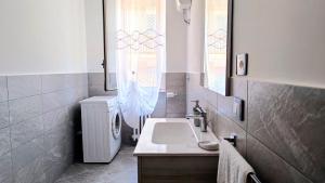 a bathroom with a sink and a toilet and a window at MaisonV-Vivi il centro e il mare in Porto San Giorgio