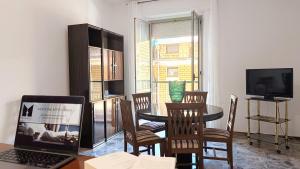 a living room with a table and chairs and a laptop at MaisonV-Vivi il centro e il mare in Porto San Giorgio