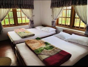 duas camas em um quarto com duas janelas em Acme Divine View em Nuwara Eliya mais 19 fotografias