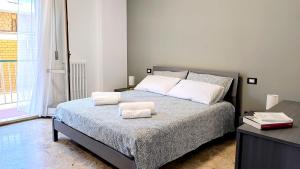 a bedroom with a bed with two towels on it at MaisonV-Vivi il centro e il mare in Porto San Giorgio