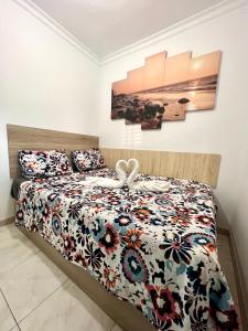 a bedroom with a bed with a floral bedspread at Tropicalife in Playa del Ingles