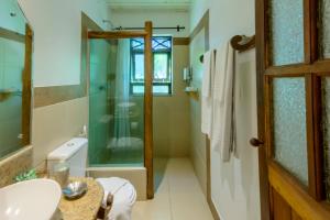 a bathroom with a glass shower and a sink at Pousada Vila Serrano in Lençóis