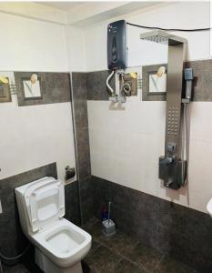 uma casa de banho com WC e um telefone na parede em Acme Divine View em Nuwara Eliya