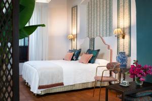 a bedroom with a white bed and a table and chairs at Cortijo Torre De La Reina in Torre de la Reina