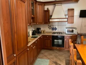a kitchen with wooden cabinets and a stove top oven at Appartamento al lago in Corgeno