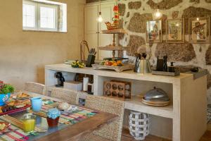 a kitchen with a table with food on it at Casa do Xico - Minho's Guest in Guardizela