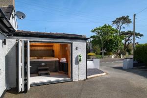 a small building with a bed inside of it at Pencraig Cottage Indoor Hot Tub in Amlwch