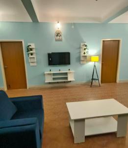 a living room with a tv and a couch and a table at Flickstays Blossom in Bangalore