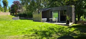 a small black house in a field of grass at Loft de jardin le 8 in Locminé