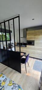 a kitchen with a table and a chair in a room at Loft de jardin le 8 in Locminé