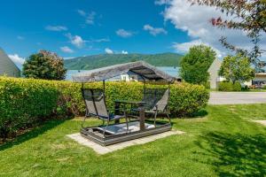 two chairs and a table in the grass at La Familliale 69 - 3 chambres - 7 personnes in Saint-Férréol-les-Neiges