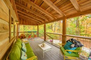 un porche grillagé avec un canapé vert et des chaises dans l'établissement Cabin Porch Paradises, à Unionville