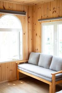 a couch sitting in a room with two windows at B&H Villa - Villa has swimming pool in Lang Co