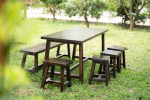 a picnic table and four stools in the grass at B&H Villa - Villa has swimming pool in Lang Co
