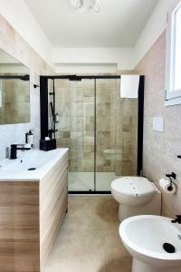 a bathroom with two sinks and a toilet and a shower at Ferrari Rooms & Apartments in Porto Cesareo