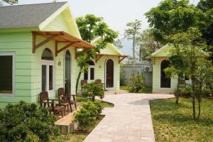 a green house with a porch and a patio at B&H Villa - Villa has swimming pool in Lang Co