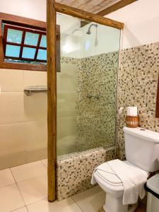 a bathroom with a glass shower and a toilet at Pousada Vila Serrano in Lençóis