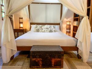 a bedroom with a bed with a canopy and a trunk at Pousada Vila Serrano in Lençóis