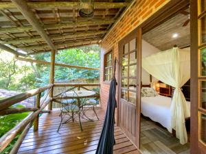 a room with a bed and a table on a deck at Pousada Vila Serrano in Lençóis