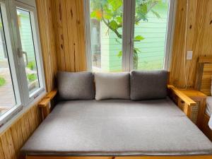 a couch in a room with two windows at B&H Villa - Villa has swimming pool in Lang Co