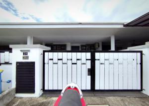 a person is sitting in front of a gate at AA Homestay Bandar Mahkota Banting in Banting