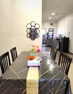 万津AA Homestay Bandar Mahkota Banting的餐桌,配有黑色桌布和鲜花