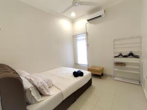 万津AA Homestay Bandar Mahkota Banting的一间卧室配有一张带白色床单的床和一扇窗户。