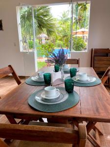 a wooden table with plates and cups on it at Pousada Oceano Atlântico in Barra Grande