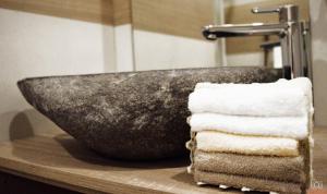 kamienna umywalka w łazience z ręcznikami na ladzie w obiekcie Villa Ceirano w mieście Lagnasco
