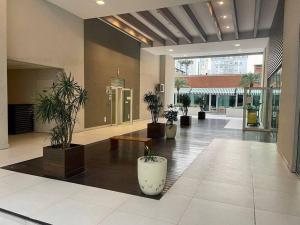 a lobby with potted plants in a building at Espaço especial IX in Curitiba +1 photo
