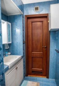 a bathroom with a wooden door and a sink at 5 min dalla Spiaggia Terrazza Vista Mare in Zoagli