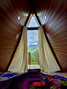 a bedroom with a window in a wooden wall at Wrongturnclub hilltop adventure stay in Kūkkāl