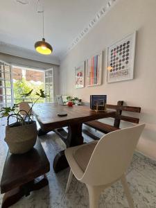 a dining room with a wooden table and white chairs at Comfort and Sunny Apartment, Marousi OAKA Stadium Neratziotissa in Athens