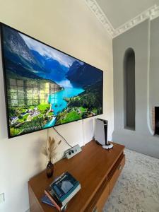 a large flat screen tv hanging on a wall at Comfort and Sunny Apartment, Marousi OAKA Stadium Neratziotissa in Athens