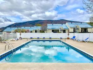 a swimming pool with chairs and a house at L'Érablière 75 - 3 chambres - 7 personnes in Saint-Férréol-les-Neiges