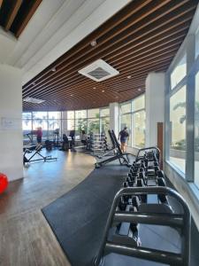 a gym with rows of treadmills and people in the background at Nordic Rsquare Manila - with Pool Access in Manila