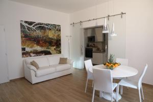 a living room with a white couch and a table at Anna & Salvo's House in Marsala
