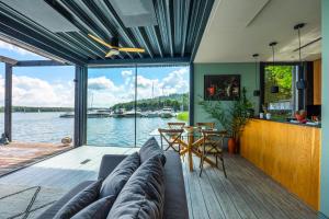 a living room with a couch and a view of the water at Loft na wodzie - Bogaczewo in Bogaczewo