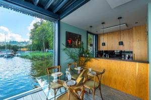 a dining room with a table and a view of the water at Loft na wodzie - Bogaczewo in Bogaczewo +27 photos