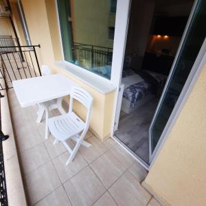 a balcony with a table and chairs and a bedroom at Studio Apartment with Pool View, Sunny Beach in Sunny Beach