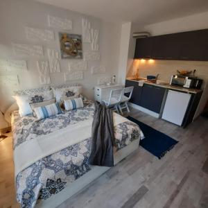 a bedroom with a large bed and a kitchen at Studio Apartment with Pool View, Sunny Beach in Sunny Beach