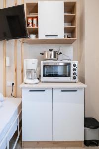 a kitchen with a microwave on a white cabinet at Athanias Studio in Drama