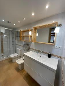 a bathroom with a toilet and a sink and a toilet istg at Apartamentos Playa Galizano in Galizano +37 photos