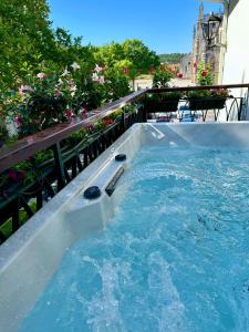 a jacuzzi tub on a balcony with flowers at Hotel Lis Batalha in Batalha
