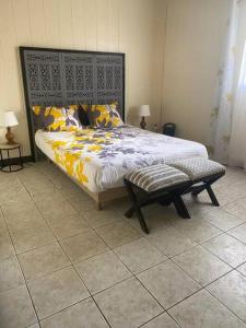 a bedroom with a large bed and a bench at Chez Ti Roland et Josie in Le Tampon