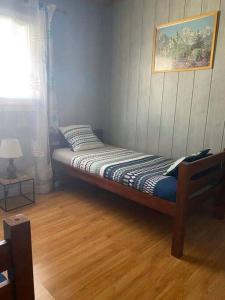 a bed in a room with a wooden floor at Chez Ti Roland et Josie in Le Tampon