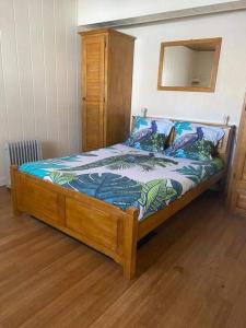 a bed with a wooden frame in a bedroom at Chez Ti Roland et Josie in Le Tampon