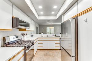a kitchen with white cabinets and a stove at Golf, Hike and Relax Cathedral City Condo in Cathedral City