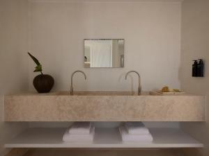 a bathroom with a large marble sink with two faucets at Akria Seaside Suites in Naousa