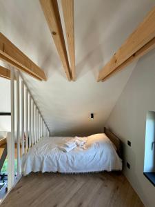 a bedroom with a bed in a attic with wooden beams at Lavender Resort in Molėtai +138 photos